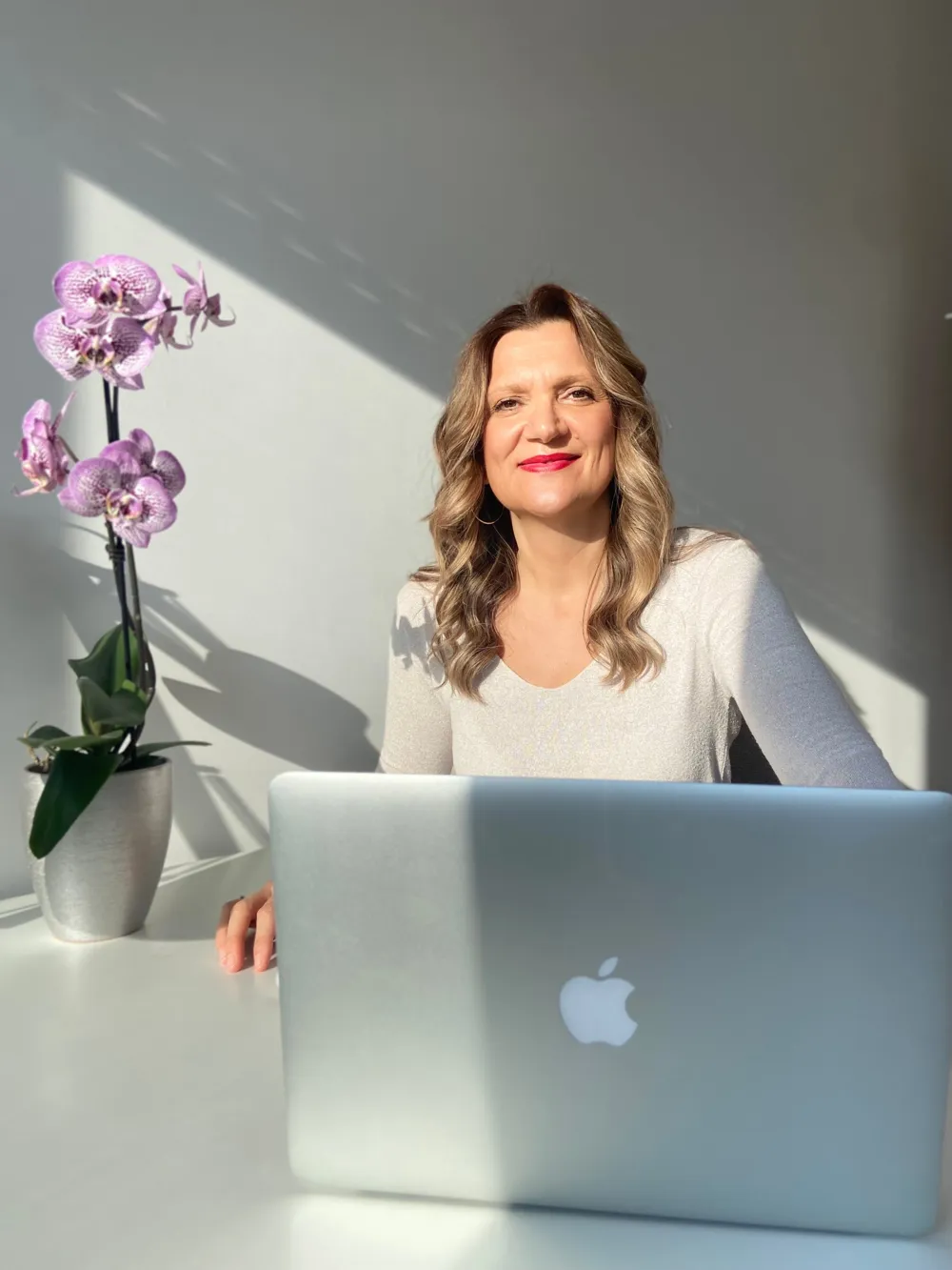 Biljana Todic alla scrivania con il Mac e un'orchidea